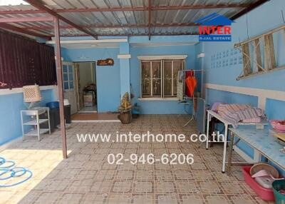 Spacious covered patio with blue walls and tiled floor