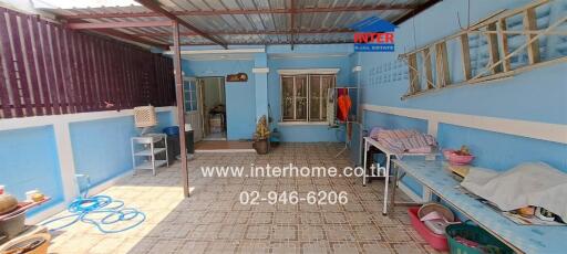 Spacious covered patio with blue walls and tiled floor