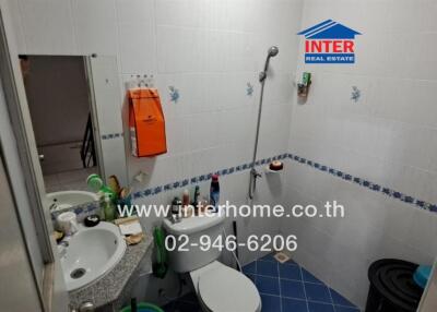 Spacious fully tiled bathroom with shower and multiple sanitary fittings