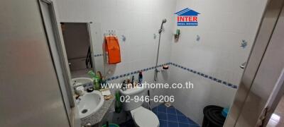 Spacious fully tiled bathroom with shower and multiple sanitary fittings