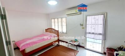 Bright and spacious bedroom with large windows and air conditioning