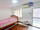 Bright and spacious bedroom with large windows and air conditioning