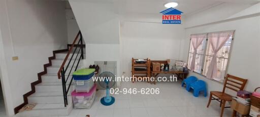 Spacious living room with staircase and ample natural light