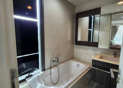 Modern bathroom with bathtub and stylish vanity under a large mirror