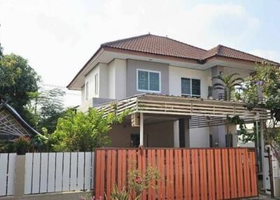 Spacious two-story house with orange gate and tiled roof