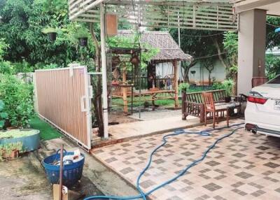 Covered patio area with car and garden