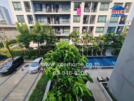 View of a modern apartment complex with swimming pool and parking