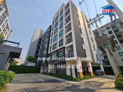 Modern residential building with security gate and clear blue sky