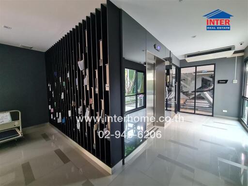 Modern lobby area with decorative dark partition and sleek flooring in a commercial building
