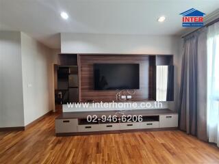 Spacious living room with modern entertainment unit and wooden flooring