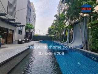 Luxurious outdoor swimming pool with surrounding lounge areas in a modern residential complex