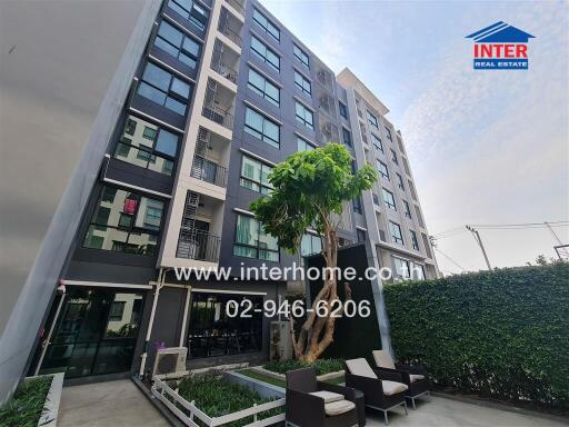 Modern residential apartment building exterior with landscaped outdoor seating area