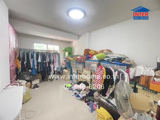 Cluttered bedroom with multiple storage racks and plush toys