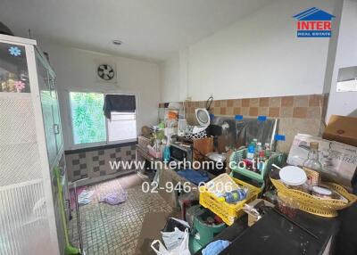 Cluttered residential kitchen with various household items and appliances