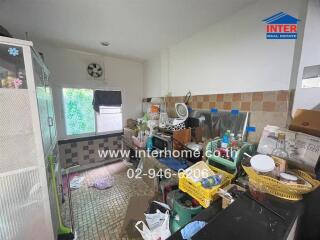 Cluttered residential kitchen with various household items and appliances