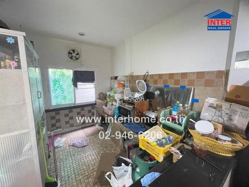 Cluttered residential kitchen with various household items and appliances