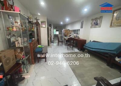 Spacious living room with tiled flooring and multiple storage units