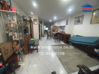 Spacious living room with tiled flooring and multiple storage units