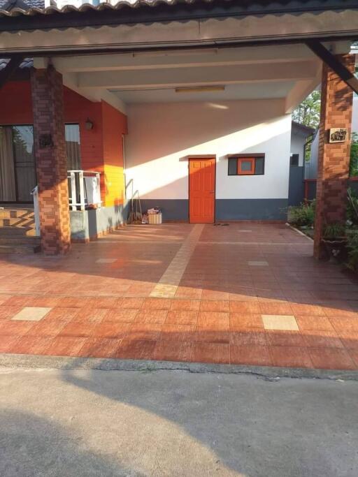 Front view of a residential house with tiled patio and brick columns