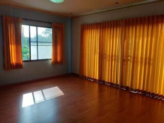 Spacious living room with ample natural light and vibrant curtains