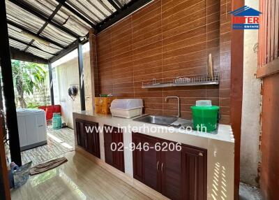 Semi-outdoor kitchen with wooden wall and modular setup