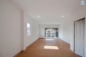 Spacious and bright empty living room with wooden flooring and large windows