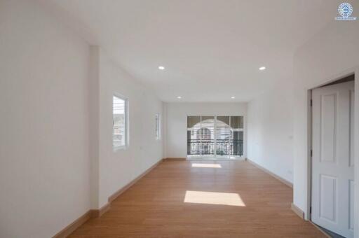 Spacious and bright empty living room with wooden flooring and large windows