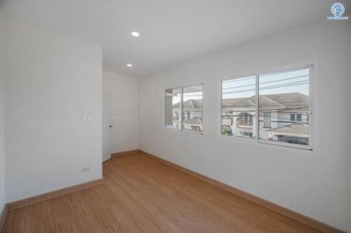 Spacious bedroom with hardwood floors and natural light