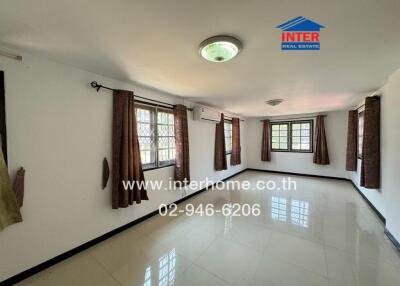 Spacious and well-lit living room with multiple windows and air conditioning