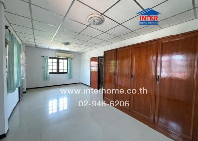 Spacious bedroom with large wooden wardrobes and tiled flooring