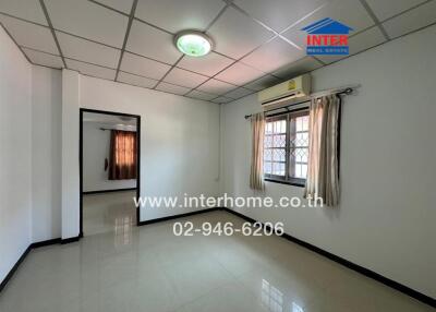 Spacious and well-lit bedroom with air conditioning and tiled flooring