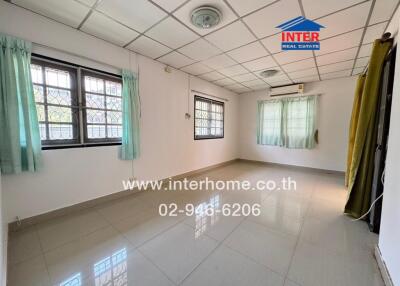 Spacious empty bedroom with multiple windows and tiled floor