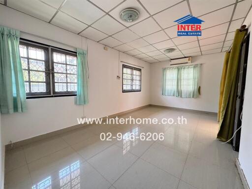 Spacious empty bedroom with multiple windows and tiled floor