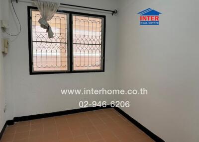 Empty bedroom with two windows and tiled flooring