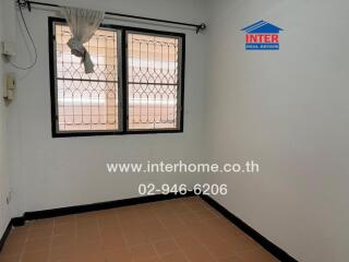 Empty bedroom with two windows and tiled flooring