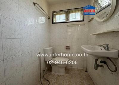 Clean and basic bathroom with white tiles, toilet, and sink