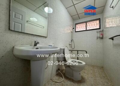 Spacious bathroom with white fixtures and tiled walls