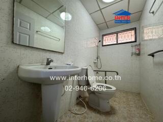 Spacious bathroom with white fixtures and tiled walls
