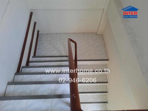 Well-maintained staircase with wooden handrails and tiled steps