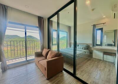 Spacious bedroom with large glass windows offering a scenic mountain view