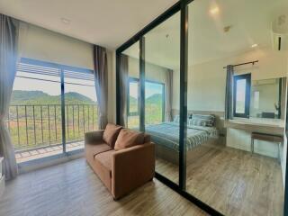 Spacious bedroom with large glass windows offering a scenic mountain view