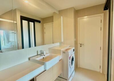 Modern apartment laundry room with washing machine and ample storage space