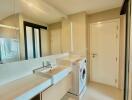 Modern apartment laundry room with washing machine and ample storage space