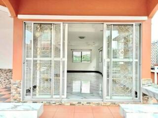 Exterior view of a house showing sliding glass doors and a tidy patio