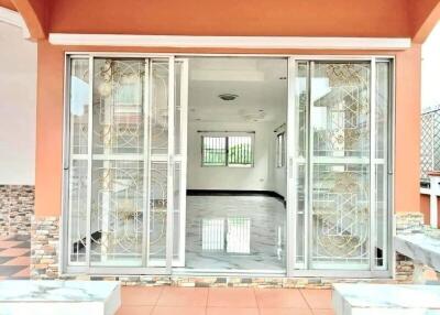Exterior view of a house showing sliding glass doors and a tidy patio