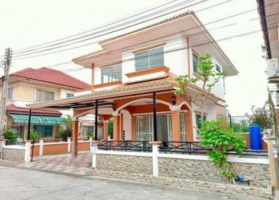 Spacious two-story residential home with orange accents and protective fencing