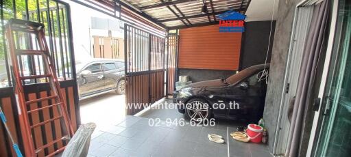 Covered carport area with sliding gate and parked car