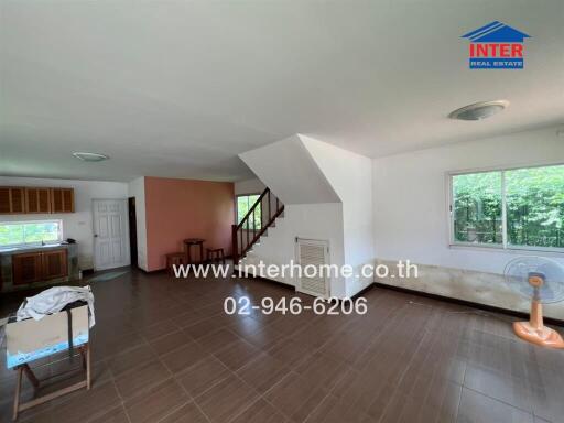 Spacious living room with staircase and large windows