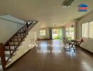 Spacious living room with staircase and large windows