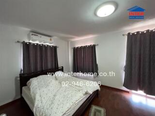 Spacious bedroom with modern furnishings, including a large bed, air conditioner, and ample lighting